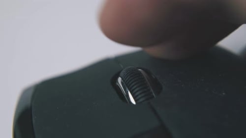Finger Scrolling on Black Computer Mouse Close Up