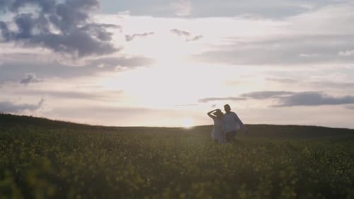 Countryside Cheerful Couple Rest in Nature Man and a Woman are Running Through a Field of Rapeseed