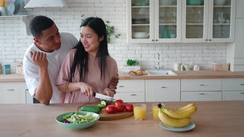 Couple preparing salad together in a bright kitchen
