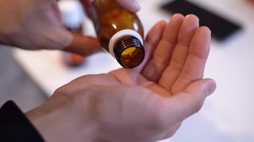 Pouring Pills from Prescription Bottle into Hand