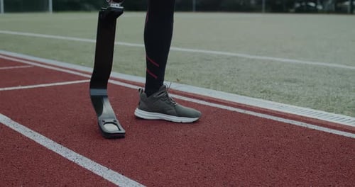 Crop View of Disabled Male Person with Prosthesis Standing at Sports Field