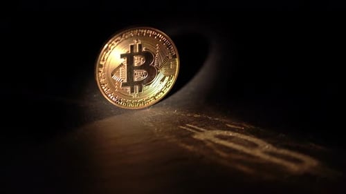 Glänzendes Bitcoin-Rotationslicht auf einer Holzoberfläche