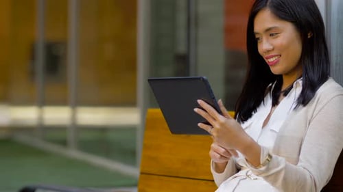 Woman Using Tablet Device Sitting Outside