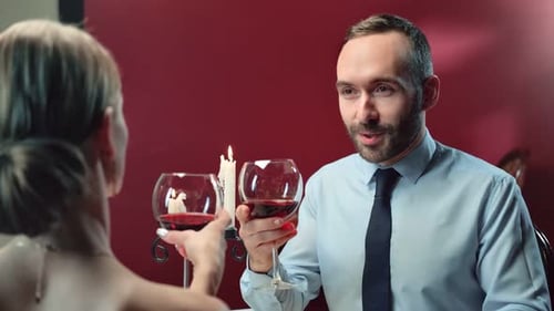 Romantic Couple Clinking Wine Glasses by Candlelight