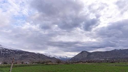 Majestic Mountain Range Behind Green Field