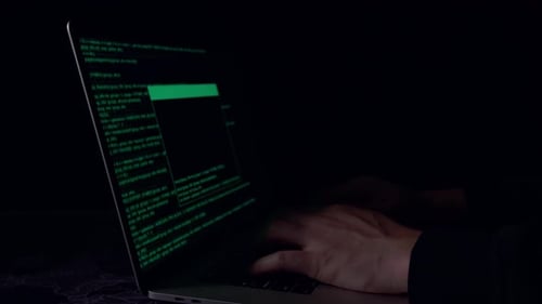 Typing Code on Laptop Screen in Dark Room