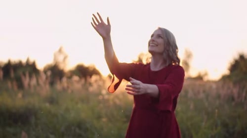Happy Woman Tossing Hat in Golden Field