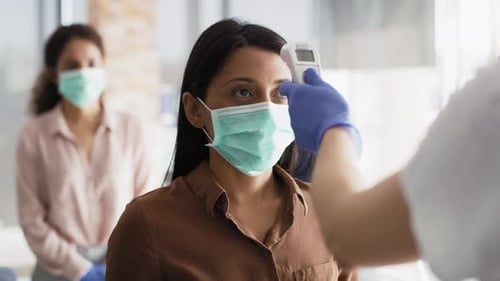 Video of employees going through mandatory temperature checks in office.