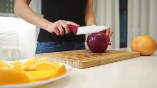 Young Adult Cutting Red Apple in Kitchen