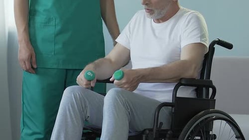 Senior Man Exercising With Dumbbells in Wheelchair