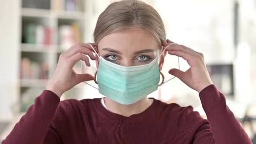 Woman Putting On a Surgical Face Mask