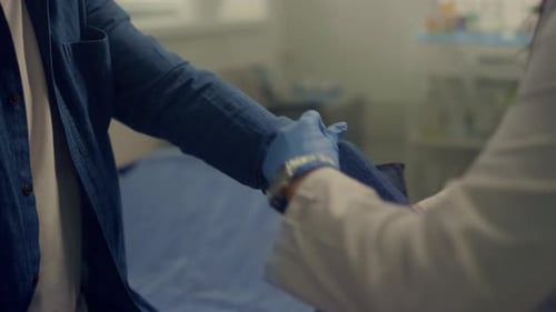 Woman Doctor Putting Cuff Measuring Blood Pressure on Old Man Arm Close Up