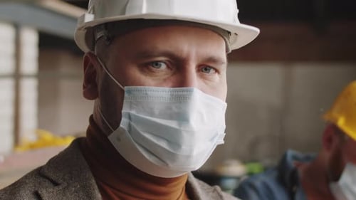 Close Up of Man Wearing Hard Hat and Mask