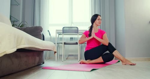 Woman Practicing Yoga Seated Twist Pose at Home