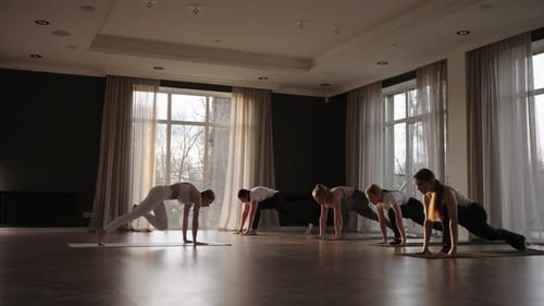 Women in Yoga Class Transitioning Through Poses