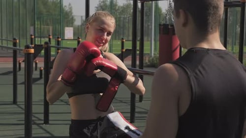 Fit Woman Boxing with Partner Outdoors