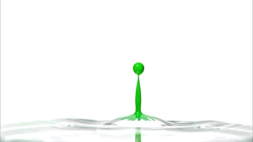 Droplet of green ink dropping into water and splashing