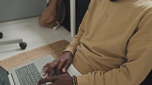 Young Adult Using Laptop in Bedroom with Headphones