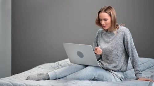 Woman On Bed Using Laptop For Video Call