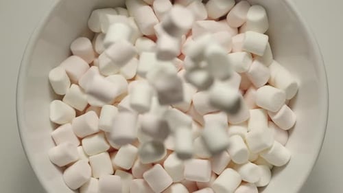 SLOW MOTION: Marshmallow Falling Into A White Bowl - Top View