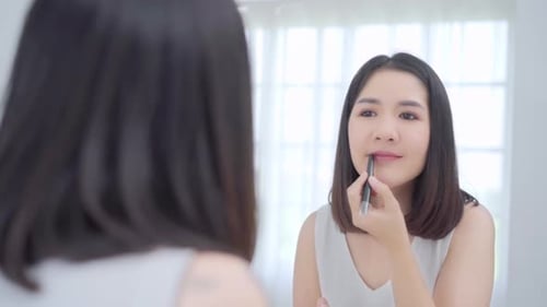 Woman Applying Lip Liner in Bathroom Mirror