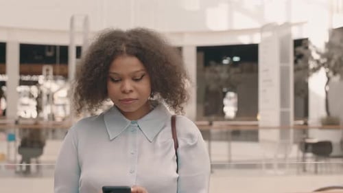 Portrait of Young Black Woman with Smartphone at Shopping Center