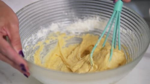 Person Mixing Batter in a Glass Bowl