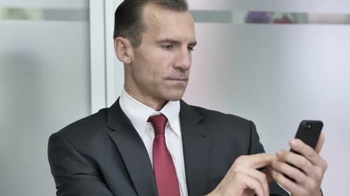 Businessman Using Smartphone in Office