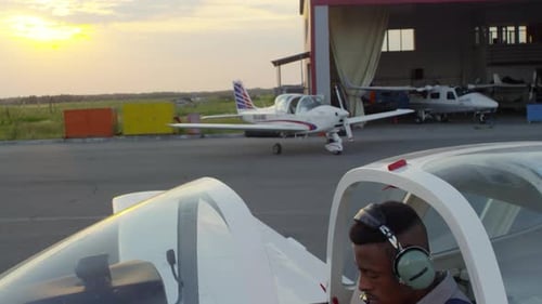 Black Pilot Sitting in Airplane Cockpit