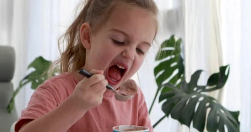 Child Eating Chocolate Ice Cream Happily Indoors
