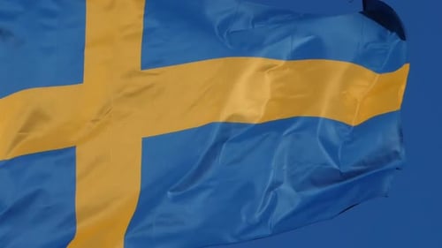 Swedish Flag Waving Against Blue Sky Background