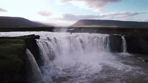 Aerial View of Majestic Waterfall in Mountainous Terrain
