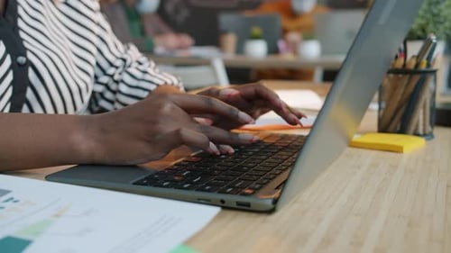 Closeup of Female Hands Working with Laptop Typing Indoors in Office