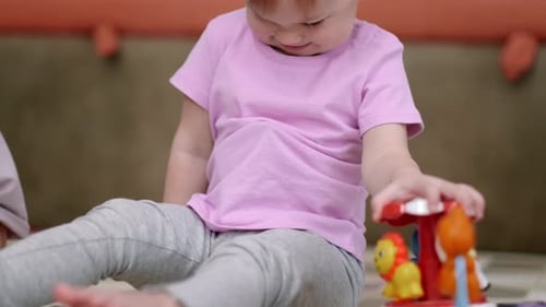 Kleines Mädchen und Mama spielen farbiges Holzspielzeug zu Hause auf dem Boden sitzen Mutter und Tochter