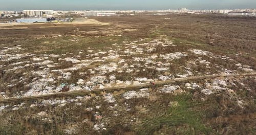 Two People Walking on a Huge Aste Garbade Dump Rubbish Landill in Bucharest