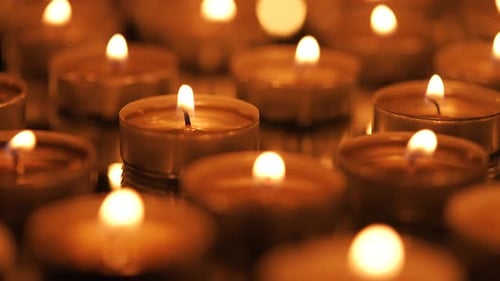 Many Small Burning Candles on a Black Background