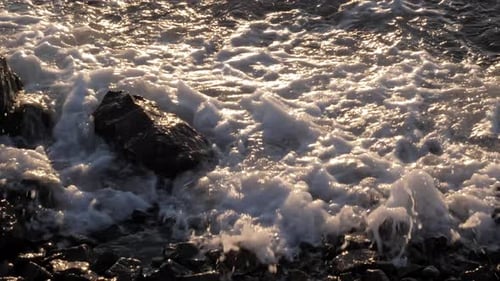 The Waves Crashing Against the Rock on the Sea Shore on the Sunset