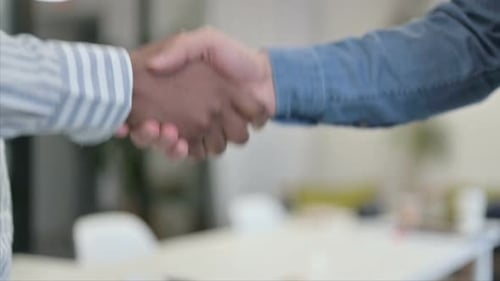 Close Up of African Man Shaking Hands with White Man