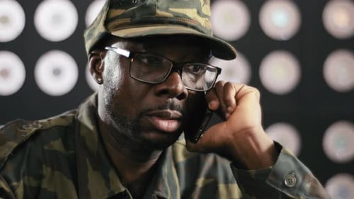 Man in Camouflage Hat Talking on Phone