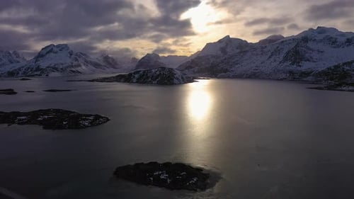 Fjord und Berge bei Sonnenuntergang im Winter. Lofoten, Norwegen. Luftbild