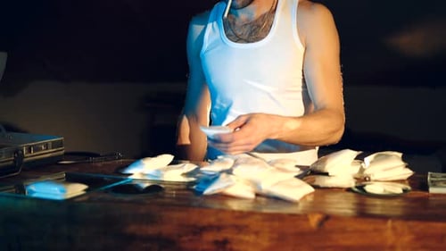 In the Underground Laboratory Drug dealer Places Packs Filled with Drugs Into the Suitcase
