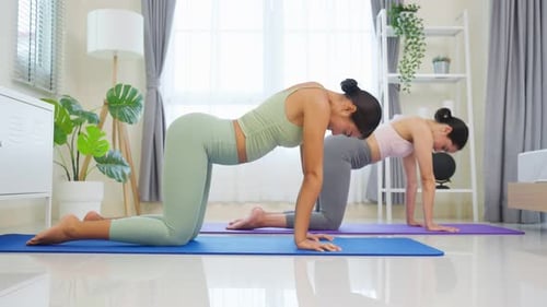 Women Practicing Yoga on Mats Indoors