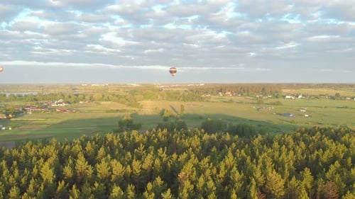 Hot Air Balloons Floating over Rural Landscape