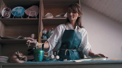 Woman Creates Pottery with Leaf Design in Studio