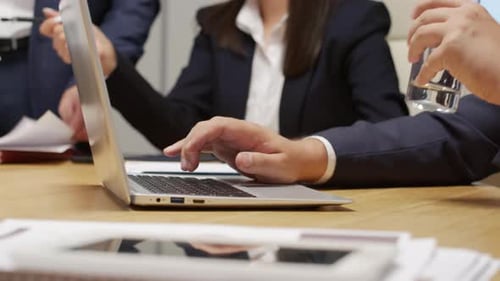 Corporate Meeting with Laptops and Documents at Table