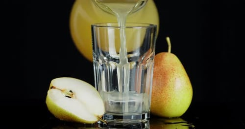 The Juice of Ripe Pears Is Poured From a Jug Into a Glass.