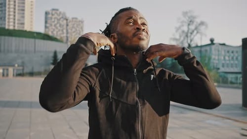 Close Up Portrait of Active African American Guy Taking Off Hood of Sweatshirt and Practicing Run