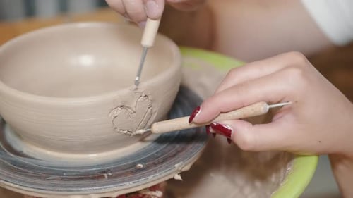 Casal apaixonado esculpindo as mãos no pote de cerâmica