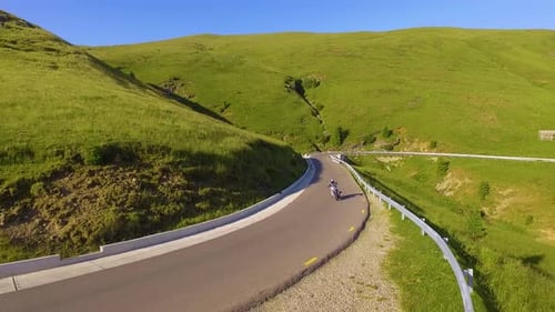 Motorcyclist driving his motorbike on the mountain road in the country side.