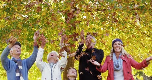 Happy Family Throws Leaves in Autumn Park